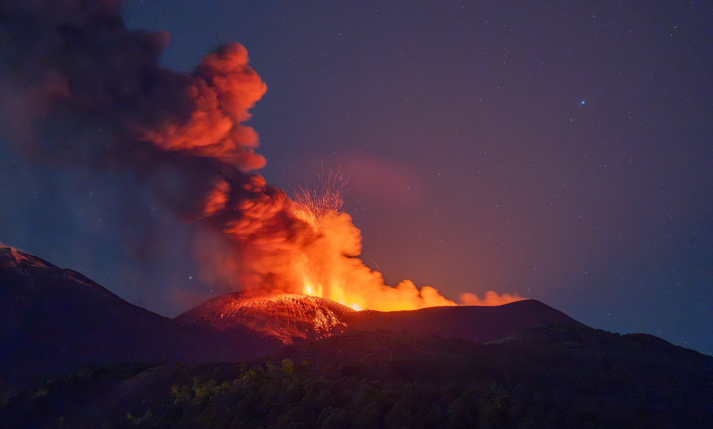 Cenere su Catania e solo 10 aerei l’ora, l’Etna non dà tregua. Negozianti spazzano i marciapiedi. Nuova colata lavica nella valle del Bove